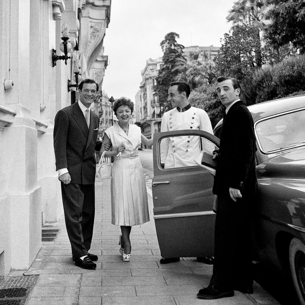 Édith Piaf, le chanteur Eddie Constantine et le chanteur-compositeur Charles Aznavour, après le thé au Grand Hôtel, Paris, 1950 photo : Marilyn Stafford.