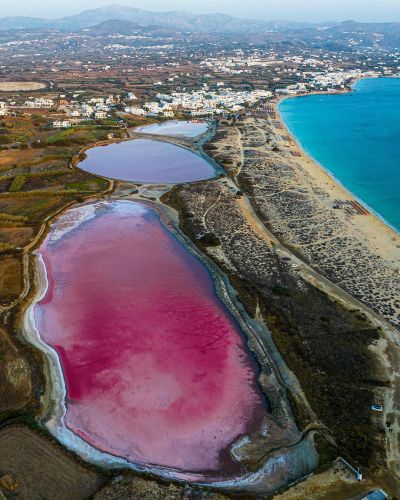 Lacs salés roses de l'île de Naxos, en Grèce. Cette teinte rose de certaines masses d'eau est associée à la présence de bactéries, de phytoplancton et d'autres micro-organismes qui peuvent survivre dans des eaux dont la salinité est particulièrement élevée. 
Photo de Michael Lv.