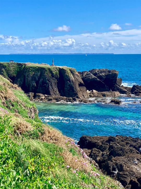 Vue sur la “Statue de Kerkorn” du sculpteur M. Bourreau (1990) et l'Île de Groix au loin de la côte à Doëlan, Bretagne, mai 2024.