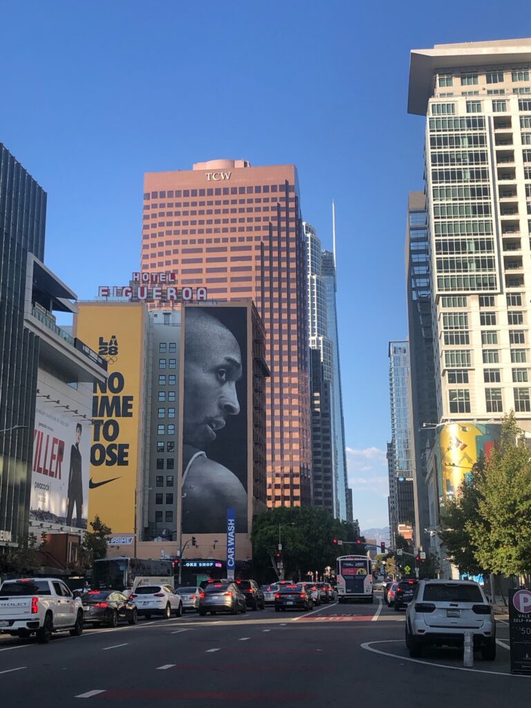 Vue depuis l'arrêt de bus, en face de la Crypto Arena. Cette publicité avec Kobe fait partie d'une campagne publicitaire de Nike pour les Jeux olympiques de Los Angeles 2028 : No Time to Lose (Pas de temps à perdre).