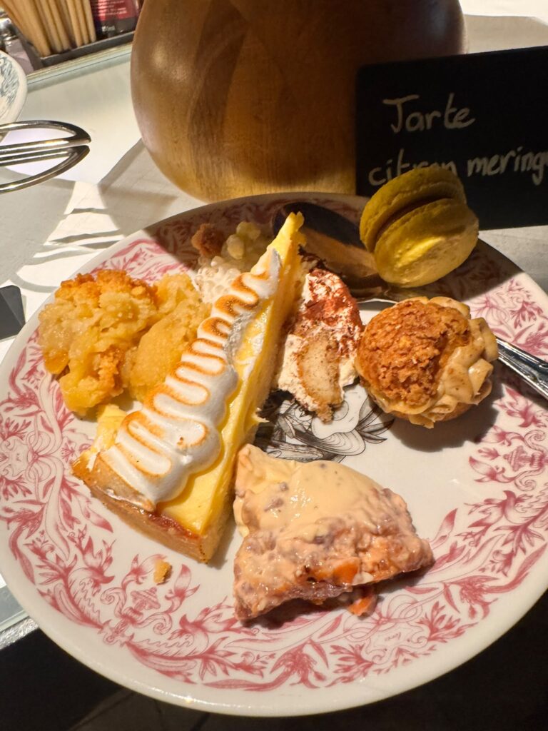 Assiette de desserts du brunch au Mama Shelter Paris East comprenant une part de tarte au citron meringuée, un macaron jaune et une pùtisserie crémeuse.