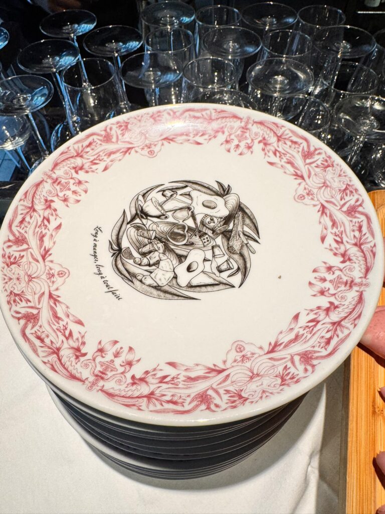 Pile d'assiettes Ă motif floral rose et dessin central, prĂȘtes pour le buffet du brunch au Mama Shelter Paris East.